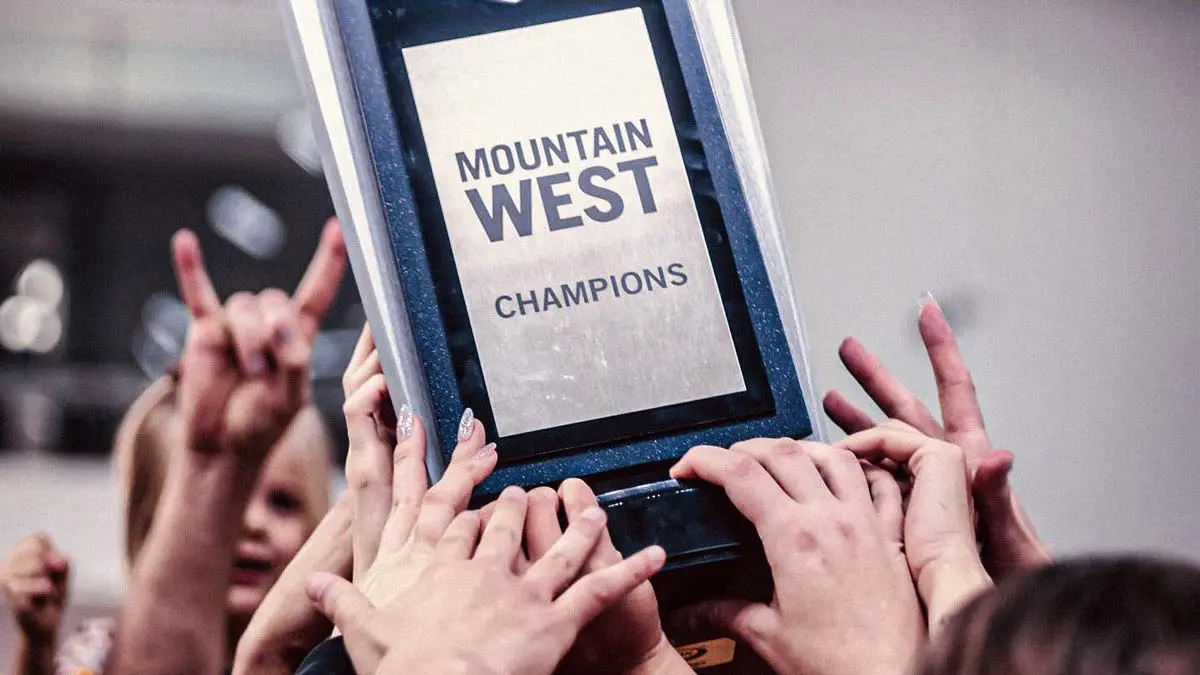 Hands holding Mountain West Champions trophy
