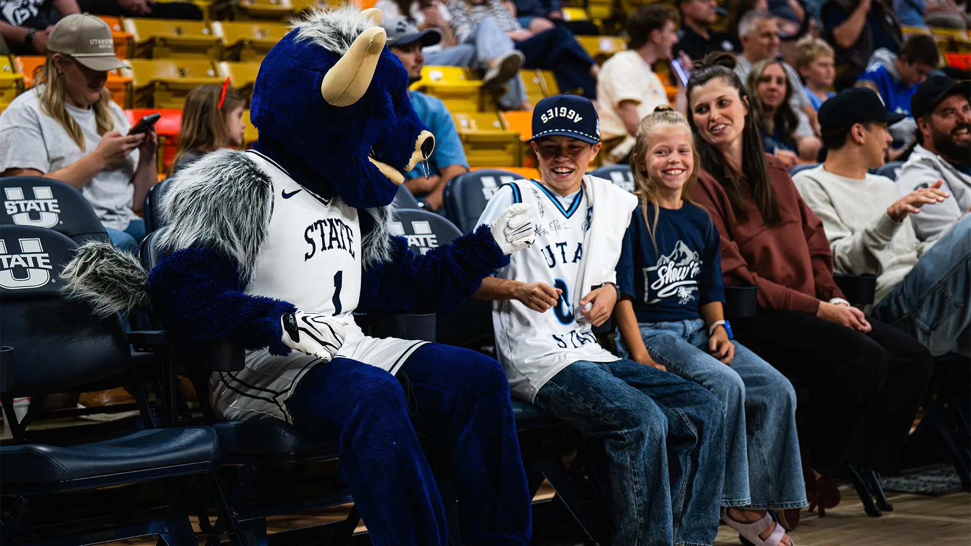 Family sitting courtside at the Dee Glen Smith Spectrum